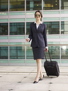 female asian business traveler with suitcase.